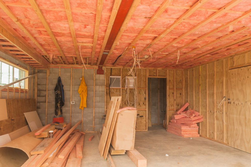 Ceiling insulation over wires in the attic is fine if it is nonflammable.