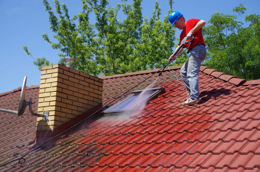 Cleaning a dirty clay-tiled roof.