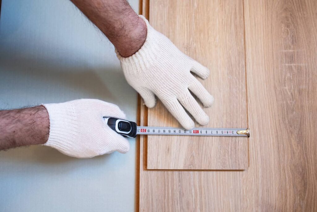 Person demonstrating how to prepare laminate flooring for stairs